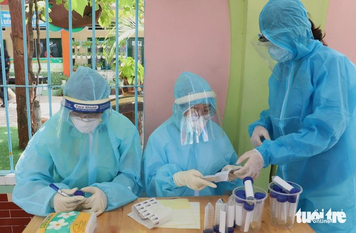 Nhân viên y tế thuộc trạm y tế TP.HCM làm việc xuyên trưa trong một cuộc lấy mẫu xét nghiệm COVID-19 toàn dân hồi đỉnh dịch COVID-19 - Ảnh: XUÂN MAI